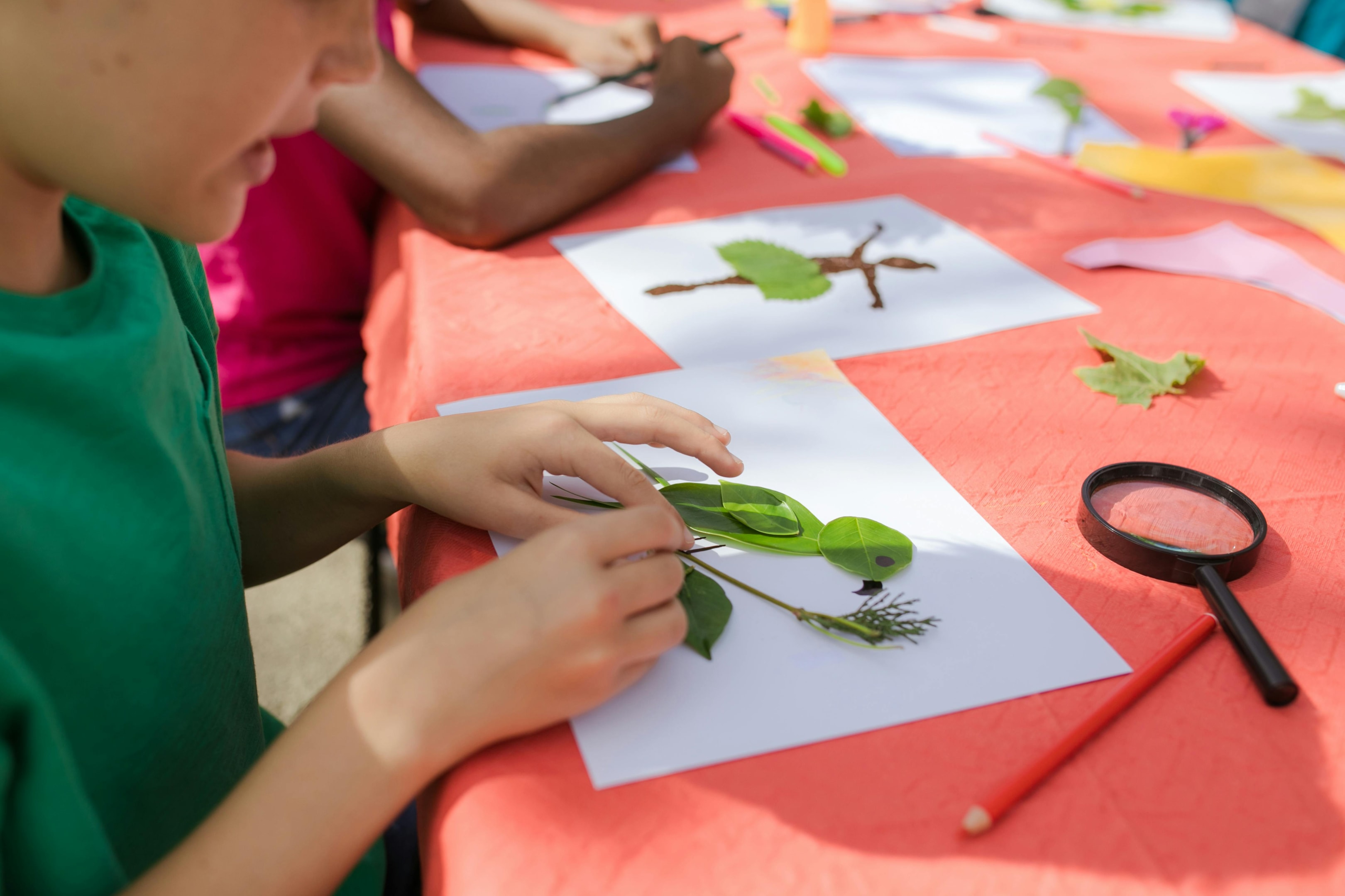 Children making birds and animals out of autumn leaves 